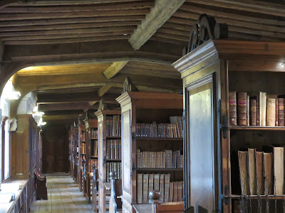 photo of librayr showing wooden shelves and old leather bound books