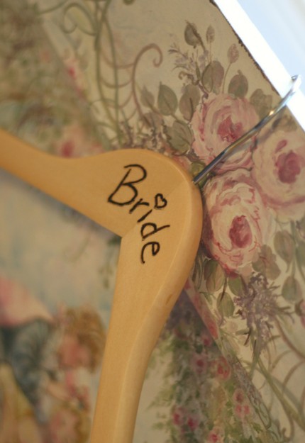 For sale is a wood hanger with the word Bride burned carved into it