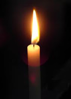 one candle burning in the darkness