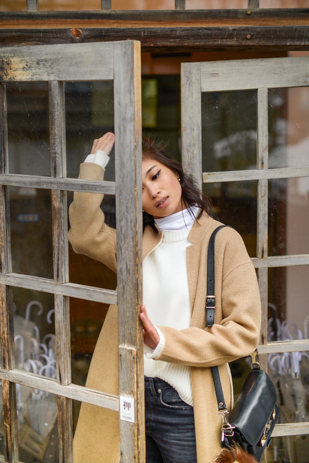 Camel coat portraits, wood and glass door close up portrait, camel double face coat, Biggest open-air bath onsen in Japan. Takaragawa Onsen, Minakami Gunma, Japan / FOREVERVANNY.com