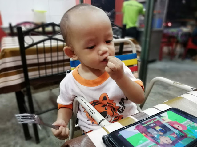 DINNER MAKAN SATAY SEDAP DI KG MELAYU SUBANG - Sehari sebelum kami fly ke Bandung Indonesia, mummy awal-awal lagi sesiap informed mak. Supaya tak payah masak dinner kitorang. Plan nak makan satay kat luar je. Mak mummy tu (Tok Mak bebudak ni) sejenis tak suka makan luar. Suka masakan sendiri. Kalau korang perasan, tiap kali makan luar bersama-sama. Kedai SATAY KG MELAYU SUBANG (depan Public Bank Kg Melayu Subang) ini je lah jadi pilihan kami. Kalau kami memilih kedai lain, tok mak budak-budak ini tak akan makan punya.  DINNER MAKAN SATAY SEDAP DI KG MELAYU SUBANG  So ...sapa cakap kami sejenis pentingkan diri, makan sedap-sedap tak ajak mak. Meh aku CILI mulut puaka tu sket ! Please lah korang, kalau boleh janganlah jaga tepi kain orang sangat ye ! Lelagi yang tak tahu luar dalam keluarga orang lain. InsyaAllah kami mampu nak jaga mak bapa kami ! Kenapa DINNER MAKAN SATAY SEDAP DI KG MELAYU SUBANG je tiap kali bawa mak, okay seperti yang tadi mummy cakap kat atas. Mak tu sejenis penggeli ! Geli nak makan air tangan sesapa masak.     kami memang duduk asing-asing..sebab tak nak, anak-anak kami ganggu masa makan tok dan tok mak depa  DINNER MAKAN SATAY SEDAP DI KG MELAYU SUBANG ini memang mak tak pernah tolak lah, sebab kedai kawan dia punya. Asalnya berpuluh-tahun dulu. Depa sekeluarga ni jiran mak.  Mak dah tahu, rumah depa, jenis bisnes satay keturnan mak depa sampai ke adik beradik depa. Memang jenis pembersih dan di yakini.  Tapi satay depa memang sedap. Daging lembu dia tu, daging fresh. Bukan daging frozen atau import. Memang 9mlm datang. Sorry ! habis ye..bye-bye.   Haaaa...gitu sekali ko !    Petang Khamis, balik kerja terus buat kira-kira duit masukkan dalam sampul sesiap. Lepas tu, mummy anta kereta pi cuci.   Banyaknya kerja sebelum pi Bandung haha.     Daddy pun siapkan ntah apa kira-kiranya, check checklists, sebelum keluar dari rumah mak. Balik dari makan satay, nak balik Kajang.  Esok pagi terus ke KLIA dan fly ke Bandung.   Fuh, travel sebelum travel gituuuu.    Kedai ini kecil je, tak besar mana. Operating hours pun ikut depa je. Selalunya weeeknd memang tak buka. Macam part time bisnes. Tapi satay depa ni memang terkenal kat Kg Melayu Subang. Dari mummy belum lahir lagi dah femes.         Ni pesen apa ntah, makan sambil nak YouTube.     Selesai dinner kami di kedai satay Kg Melayu Subang ni. Normally, aktiviti gini kami cuba buat sebulan sekali. InsyaAllah. kekonon mummy niat nak belanja semua. Tapi, selalunya daddy dah sesiap bayar.    Actually, plan awalnya...kami nak makan dengan semua adik beradik mummy. Tapi si adik tu, balik keja dah lambat. So, kami bungkuskan juga satay untuk adik. Nanti tok abah hantarkan ke rumah adik.    Lepas makan, terus memasing bergerak...kami kepala memasing ting tong. Dok rush balik Kajang, sambung kemas, gosok baju , tidurkan anak-anak dan pastikan semua siap dan sampai ke KLIA pada masa yang di tetapkan !