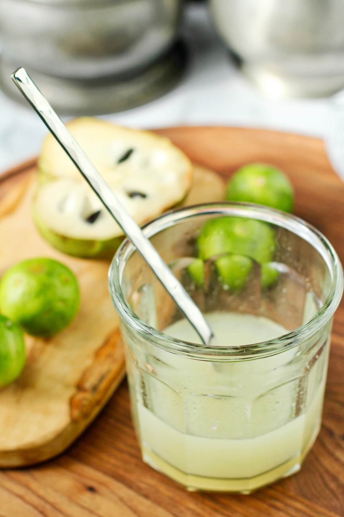 Cherimoya syrup with cut fruit and limes