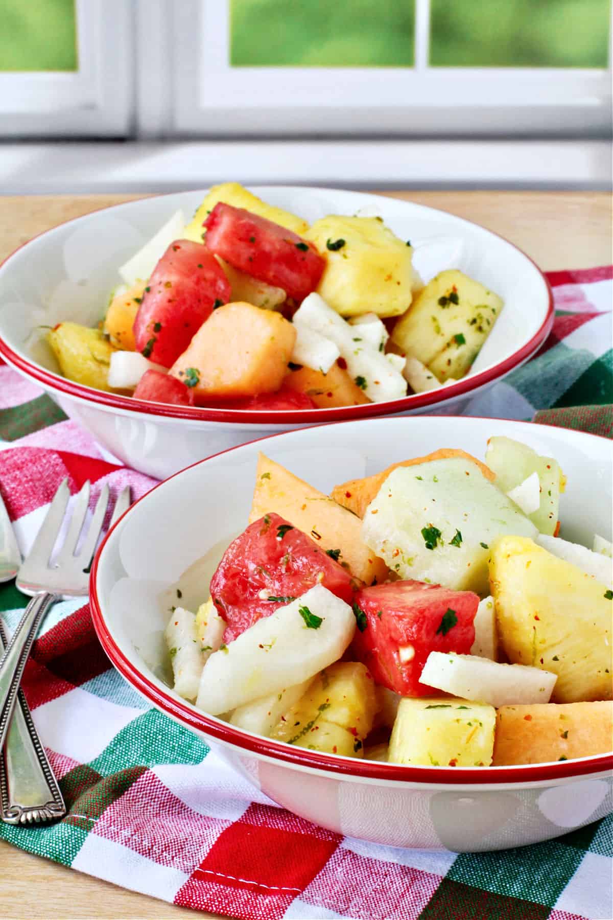 Melon, Jicama, and Pineapple Salad in white red-rimmed bowls.