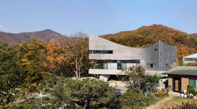 CONTEMPORARY CURVING HOUSE FEATURES A CURVING SHAPE WHICH RESEMBLES A CONCAVE LENS IN GYEONGGI-DO, KOREA