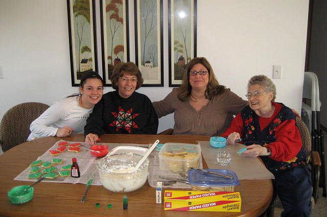 Four generations decorating Christmas cookies.