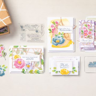 Four different floral card designs layed out on a white background next to the stamp set from the Hello Dear Friend card kit that they come from. The box containing the kit items is just showing in the corner of the picture