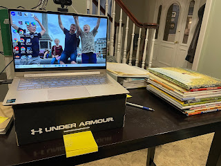 image of a computer on a shoe box, and a stack of books next to it.