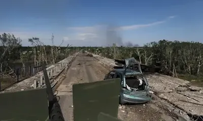 Um APC ucraniano passa por um carro destruído perto da linha de frente em Sievierodonetsk. Fotografia: EPA