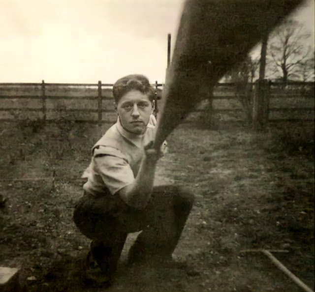 A man takes a selfie using a stick of wood to activate the camera, 1957