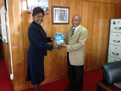 Hon. Charity Ngilu Minister for Water and Irrigatiuon  receives the SME Handbook
