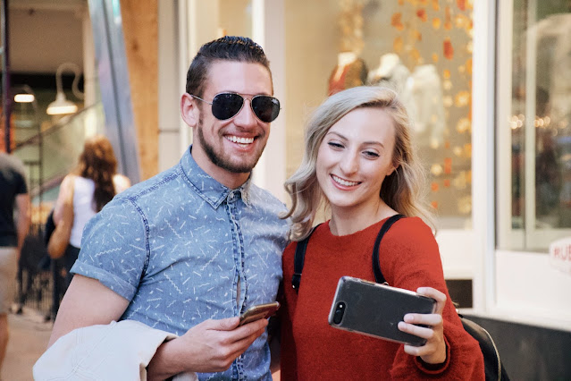 Cheerful young couple using smartphone