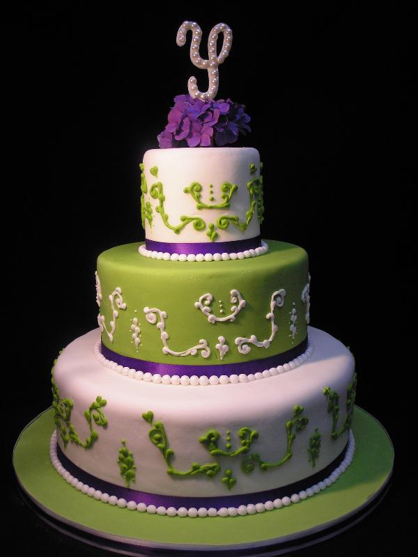 Modern three tier wedding cake with purple and green decorative circles