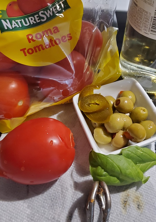 tomatoes, olives, peppers, onion and garlic used in making pork sazon