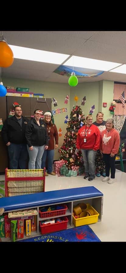 adults standing in front of a christmas tree