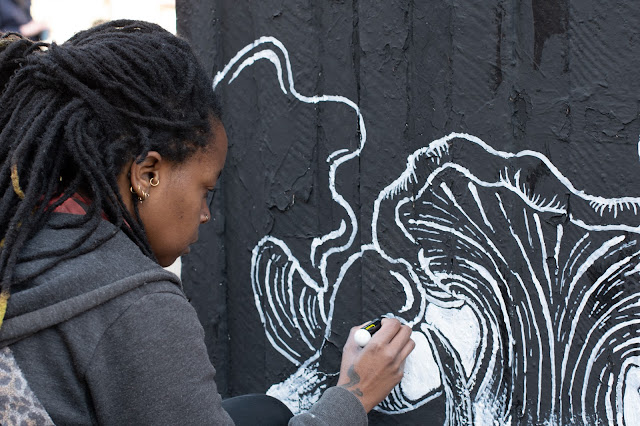 Artist Folie with white maker painting mural