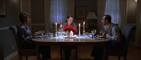 La familia Burnham cenando, con Annette Bening a la izquierda, Thora Birch iluminada en el centro y Kevin Spacey a la derecha