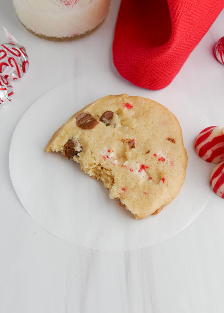 Icebox Chocolate Chip Candy Cane Kiss Cookie on a round piece of parchment paper with a bite taken.