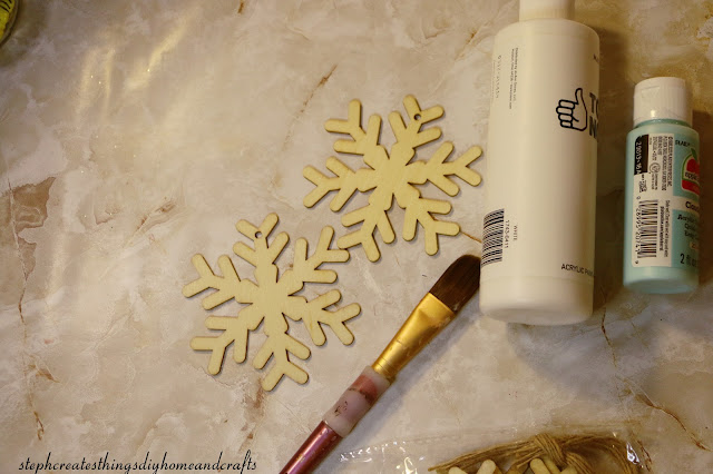 Two wooden snowflakes and acrylic paint