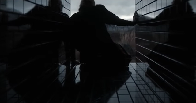 A woman crawls through a black-tiled tunnel