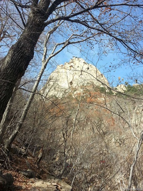 The small dark spot in the middle of the towering rock face is the Geumganggul Cave 