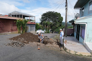 Men digging hole in street of Puriscal.