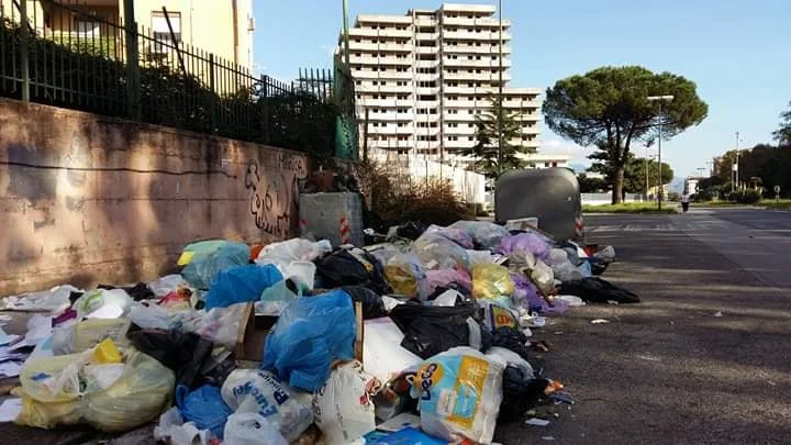 Cumuli di spazzatura e sullo sfondo la Vela verde