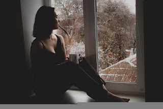 Hurt woman looking out window