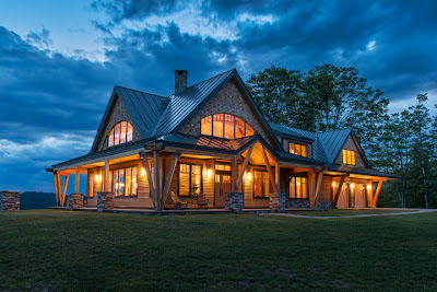 A timber home is a beacon of light on a mountain top.