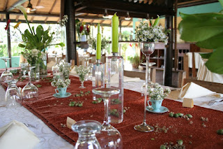 mesa de comedor servido con copas , cubiertos y plantas hornamentales