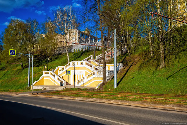 Люди поднимаются по желтой лестнице на холм