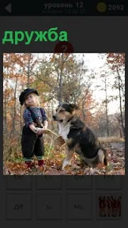 Собака дала лапу маленькому мальчику в знак дружбы на полян в лесу в знак дружбы между собой