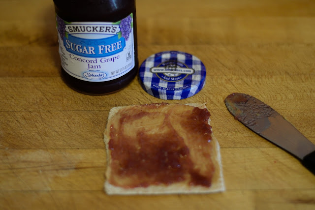 Spread the Smucker's Grape jelly over the peanut butter.