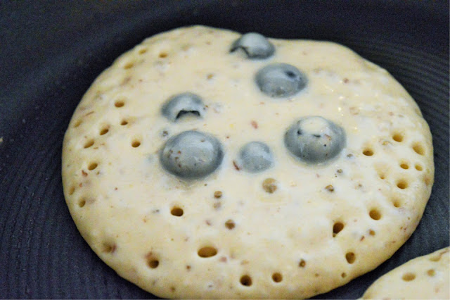 A close up of a Blueberry and Banana pancake in a pan.