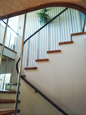 Looking up a winding staircase with a metal railing