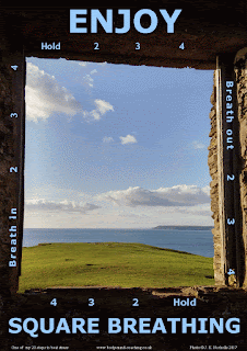 Square window with view out to sea and clouds in blue sky