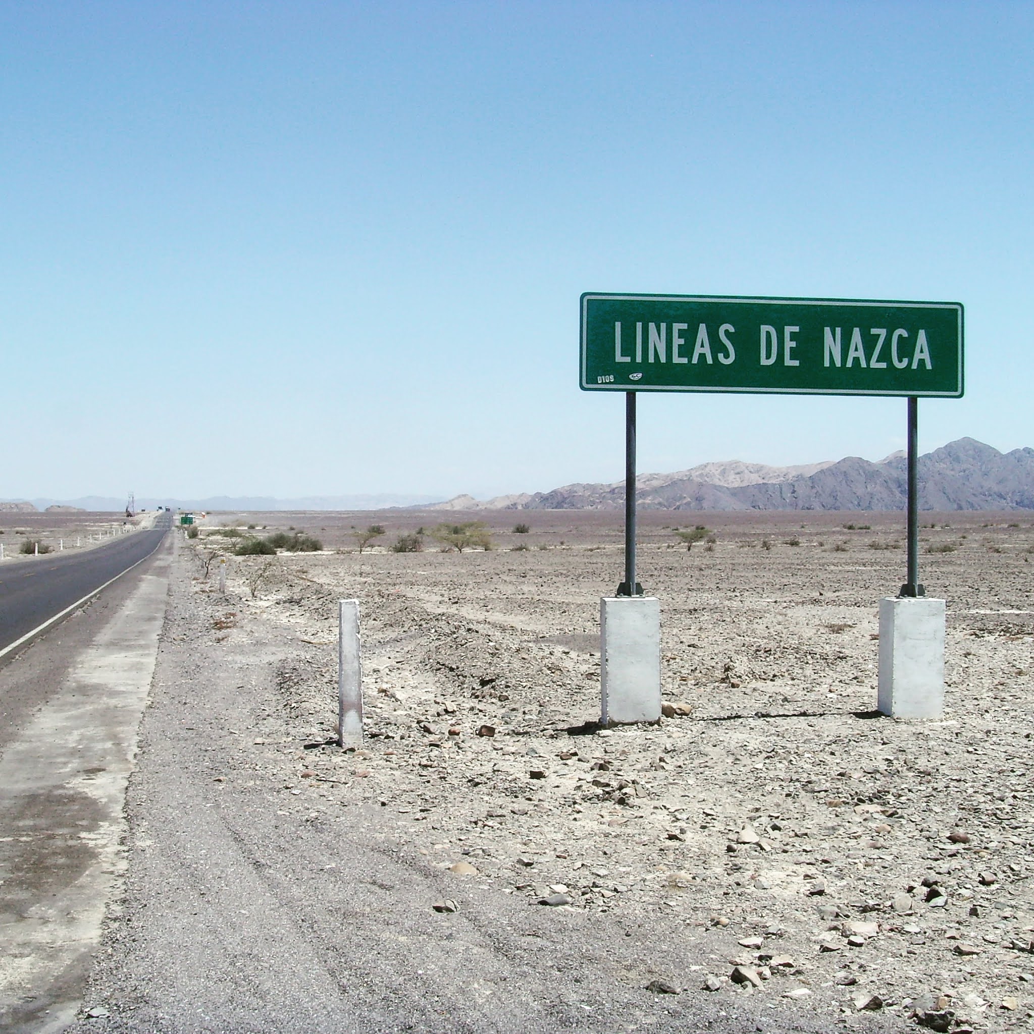 A green sign announcing the Nazca Lines in the desert of Peru, proving it's easy to see the nazca lines without flying and on a budget