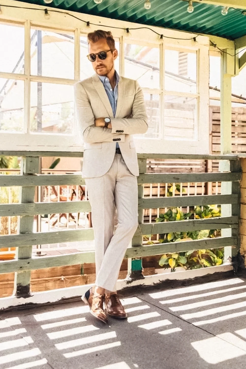 A MAN IN WEDDING SUIT IS POSING