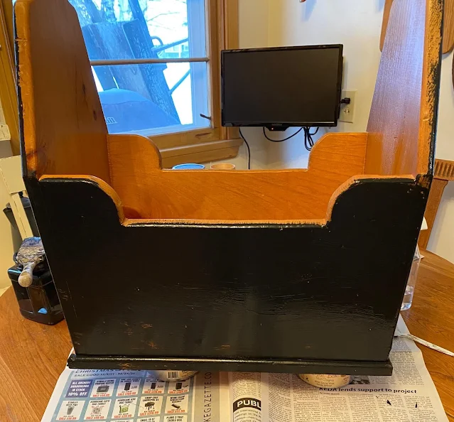 Photo of a wooden tool caddy or tote being painted with black chalk paint.