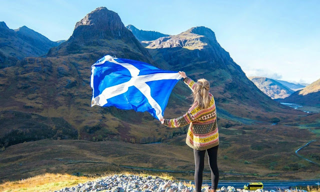 A girl screaming over the flag of scotland