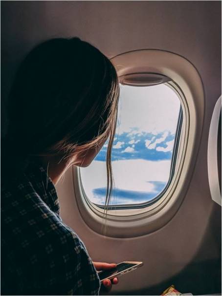 woman in an airplane looking through the window