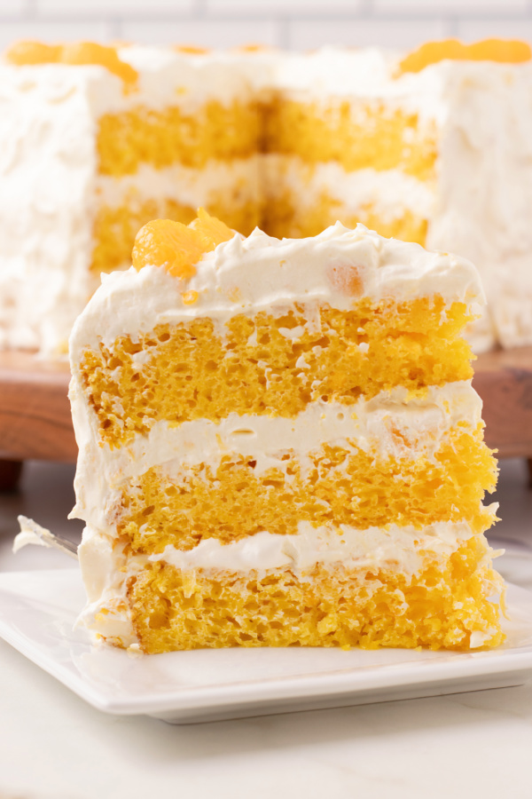 Mandarin Orange Cake! The classic box mix recipe (aka Pig Pickin' and Sunshine Cake) made with mandarin oranges, topped with the famous fluffy icing made with crushed pineapple, vanilla pudding mix and cool whip.