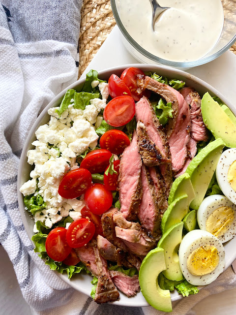Overhead shot of steak cobb salad in a bowl with ranch dressing
