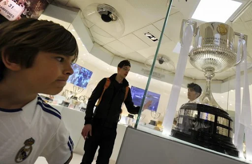 A child looks at the Copa del Rey replica on display at the museum of the Santiago Bernabéu