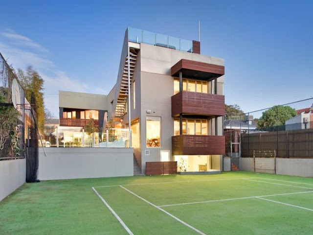 Photo of amazing modern home as seen from the tennis court in the backyard