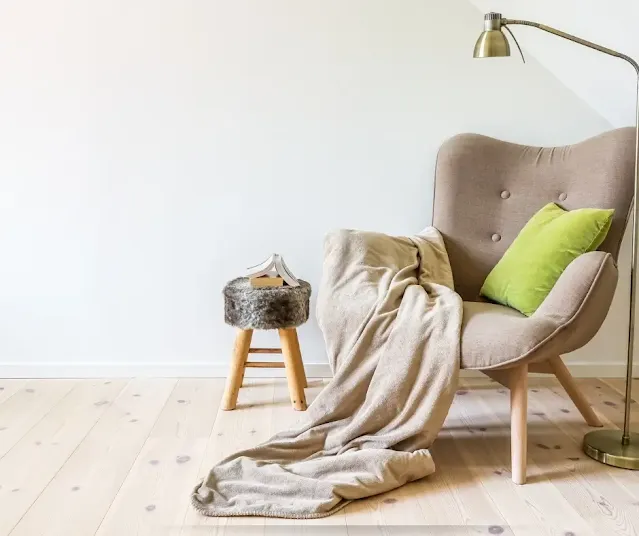 Grandma sitting in a cozy chair with a blanket.