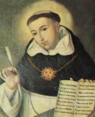 Santo Tomas de Aquino con el libro abierto y la pluma en la mano.