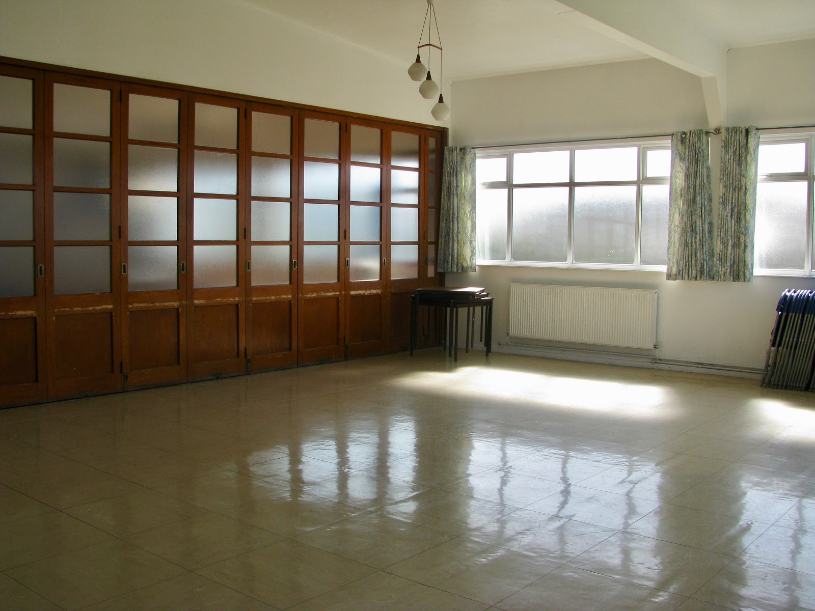 Showing floor space with linoleum floor, white walls, windows with sun shining through