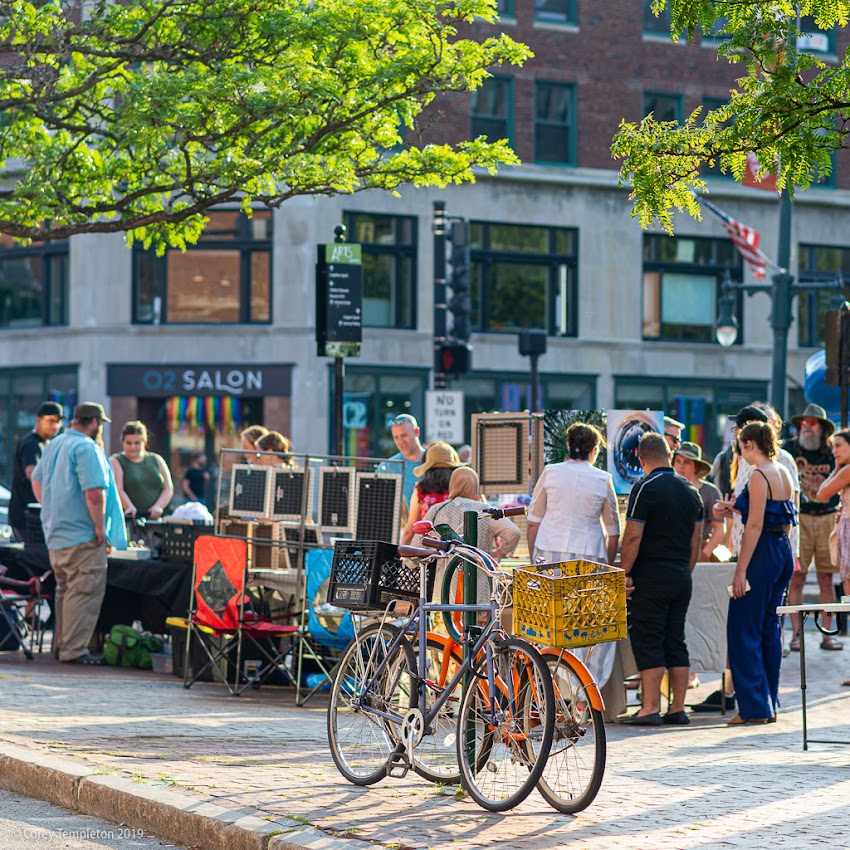 Portland, Maine USA July 2019 photo by Corey Templeton. Bicycles and artwork on the sidewalk during a First Friday.