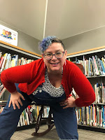 Photo of Sylvie Shaffer in front of library shelves