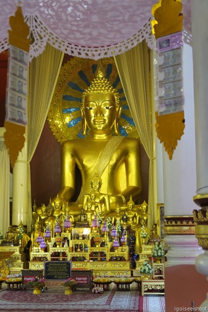 Gold and copper image of a seated Buddha inside the main prayer hall of Wat Phra Singh.